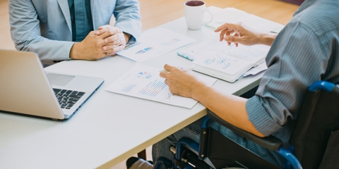 man in wheelchair doing paperwork