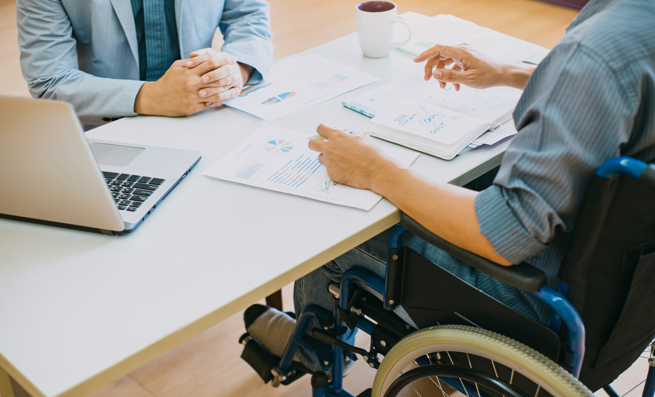 man in wheelchair doing paperwork